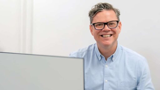 A photo of Peter Jones, Managing Director of HR Dept, next to a laptop