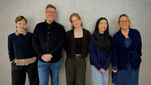 Group photo featuring Shaina Tennant, Rob Wilde, Stephanie Mackay‑Stokes, Kim Le and Vicky Walker standing together against a textured grey wall.