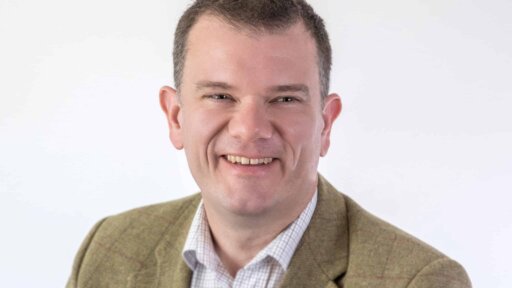 Harvey-Davies professional headshot. Smiling wearing a jacket and white shirt