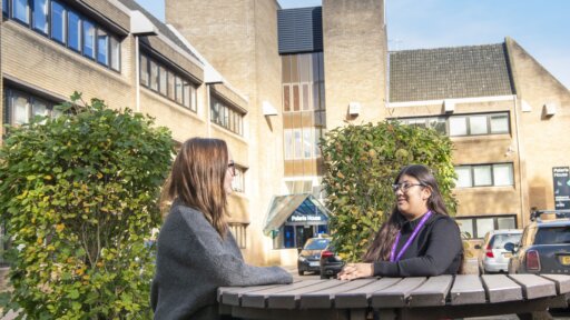 Employees talking at a picnic table outside Swindon UKSS office