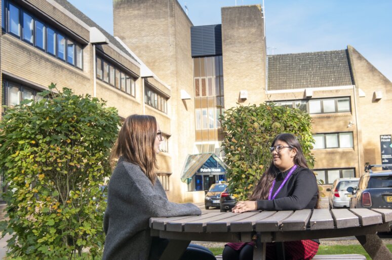 Employees talking at a picnic table outside Swindon UKSS office