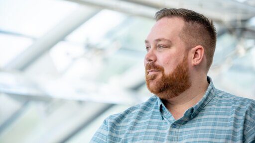 Andrew Wilkinson of Secure Safety Solutions smiling looking away from the camera with a beard and blue shirt