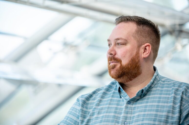 Andrew Wilkinson of Secure Safety Solutions smiling looking away from the camera with a beard and blue shirt